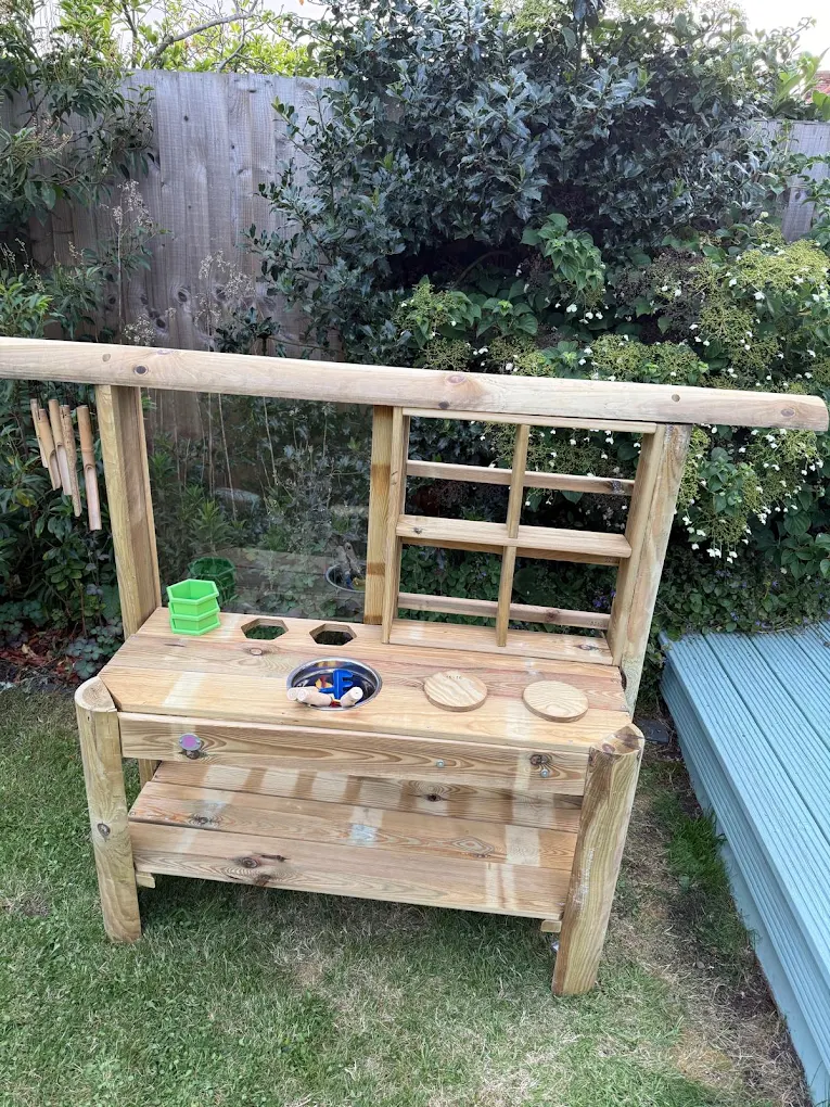 Wooden outdoor mud kitchen assembled in a garden