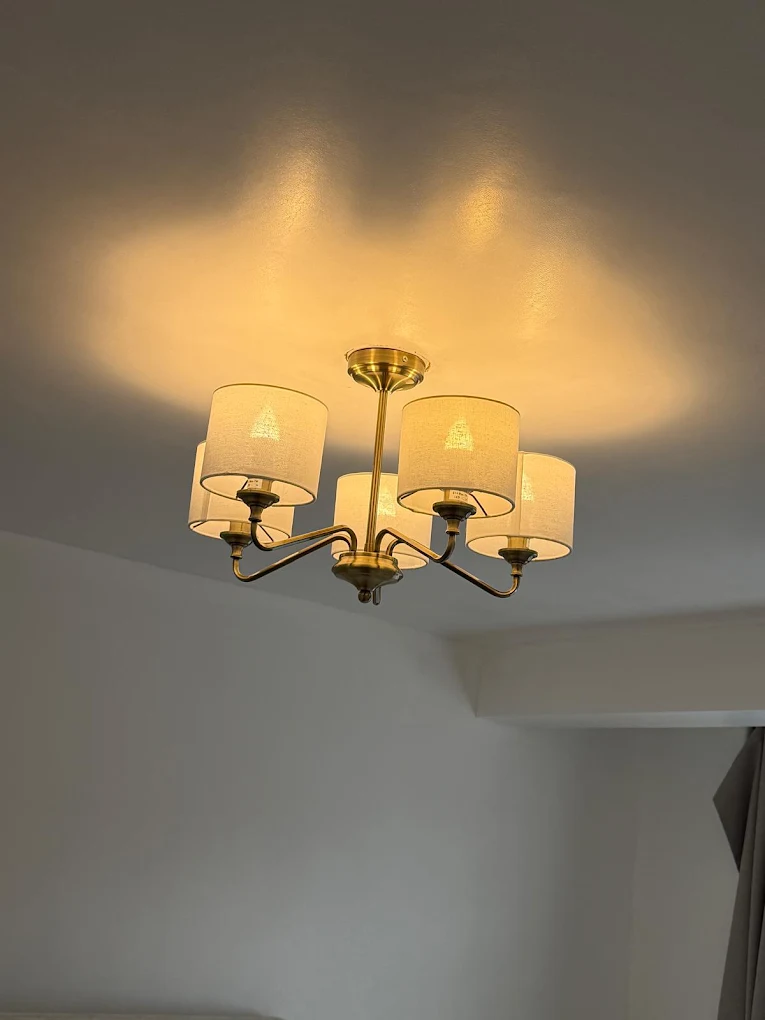 Brass five-arm ceiling light fitted in a living room