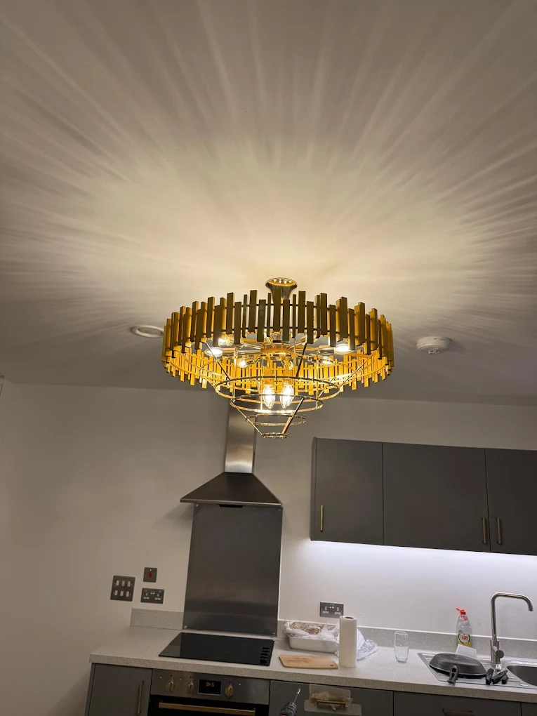 Gold statement chandelier installed in a modern kitchen